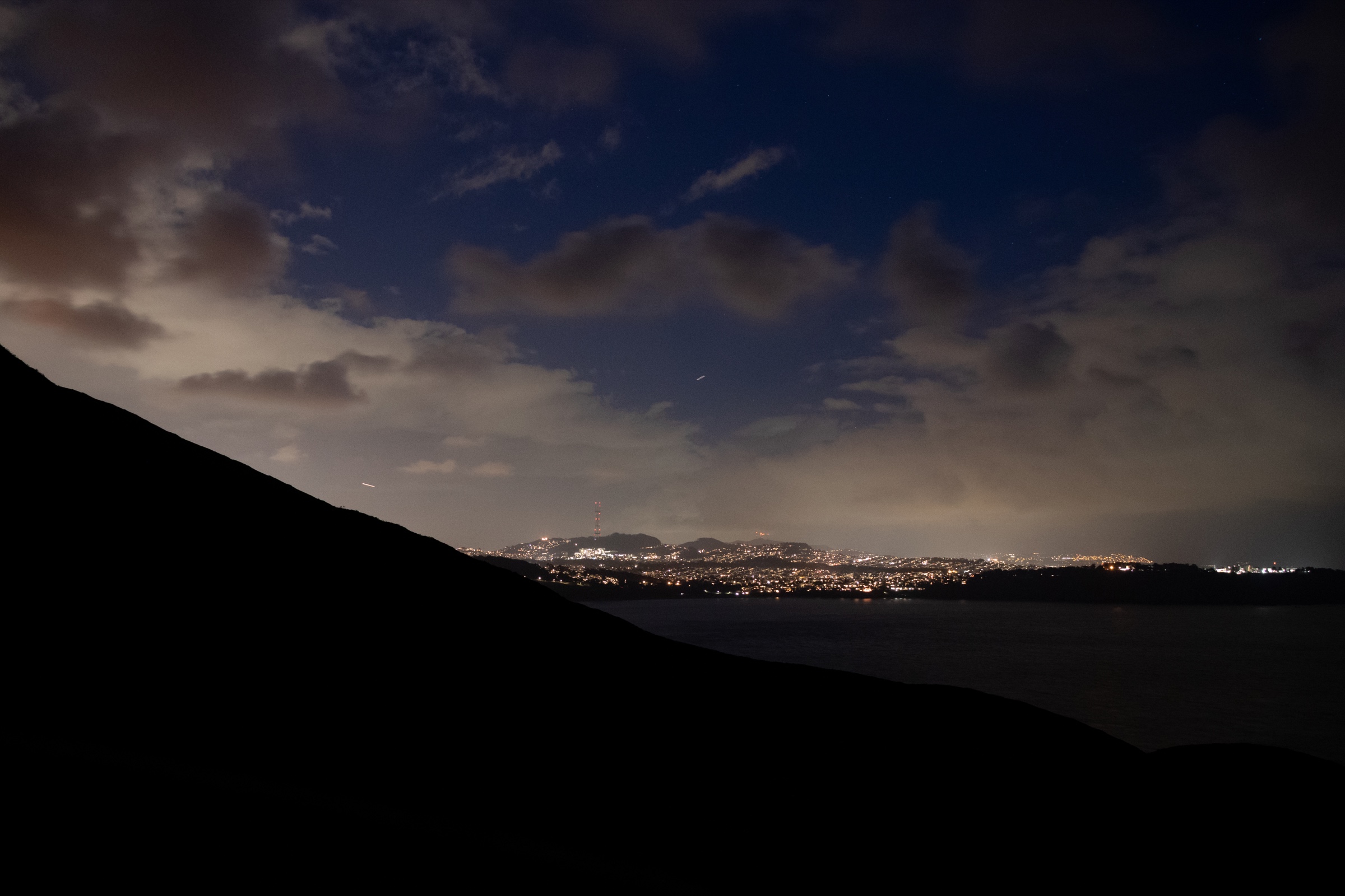 City lights at night seen from a hillside overlook