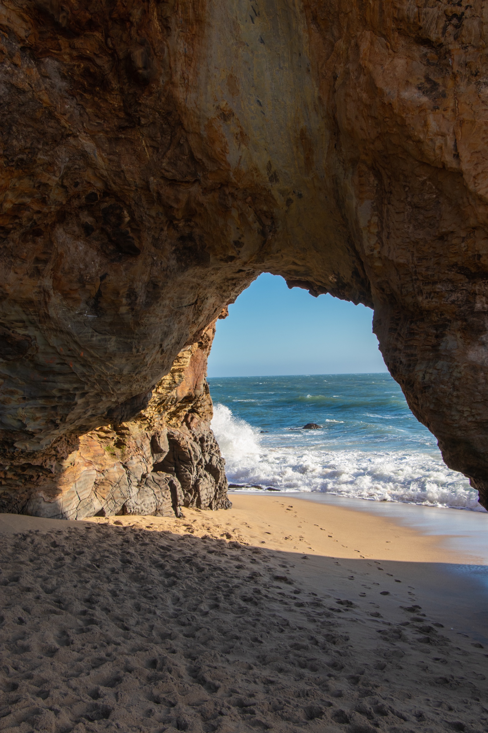View of crashing waves from inside a coastal sea cave