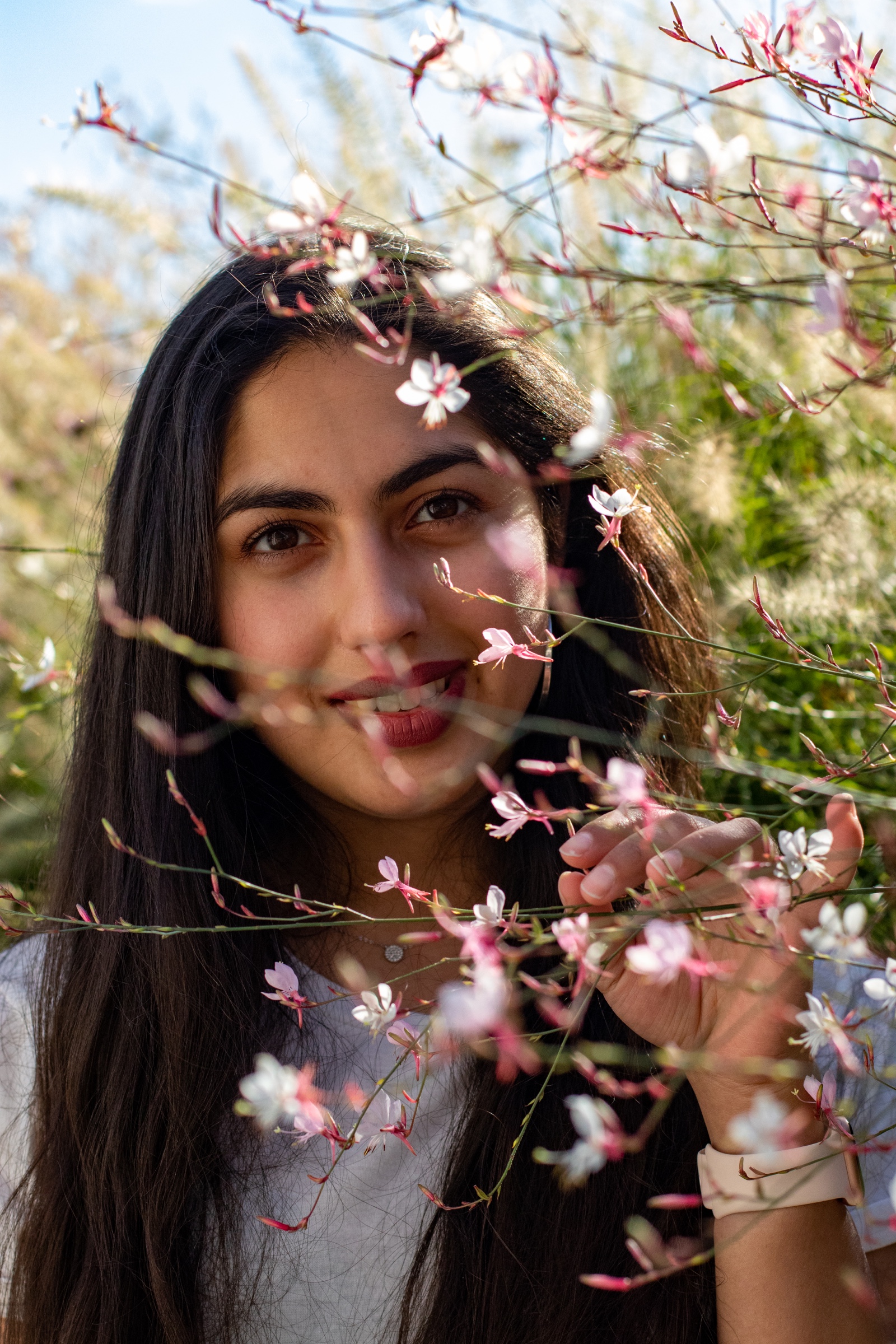 Portrait of a woman smiling through wildflower branches