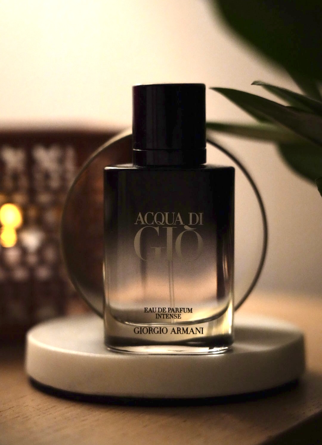 Fragrance bottle on a marble plinth in front of a brass ring